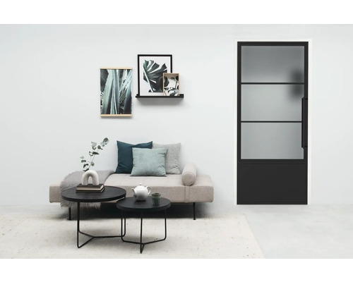 Salon avec canapé, tables basses et une porte avec insert en verre