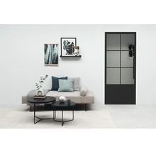 Wohnzimmer mit Sofa, Couchtischen und einer Tür mit Glaseinsatz