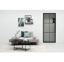 Salon avec canapé, tables basses, décorations et porte avec insert en verre