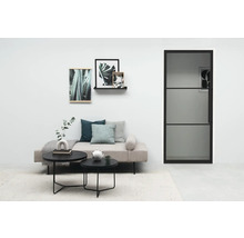 Salon lumineux avec canapé, table basse et porte à cadre en acier