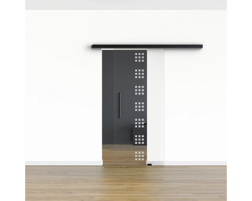 Porte coulissante en verre avec motif carré devant un mur blanc