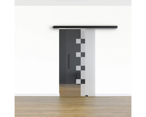 Porte coulissante en verre avec motif carré et rail noir devant un mur