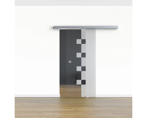 Porte coulissante en verre avec motif géométrique devant un mur blanc