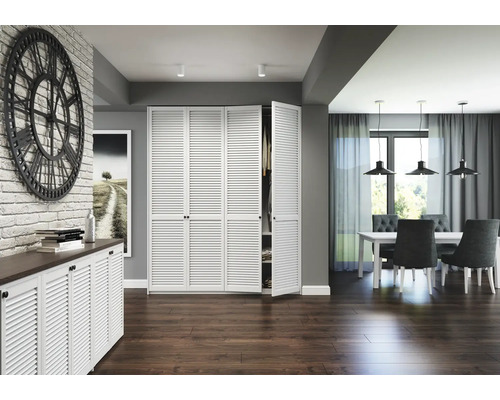 Intérieur lumineux avec armoire à persiennes blanche, commode et coin repas