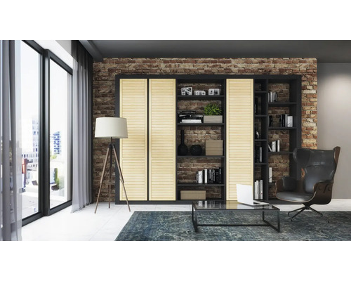 Wohnzimmer mit Bücherregal, Sessel, Stehlampe und Couchtisch auf einem Teppich