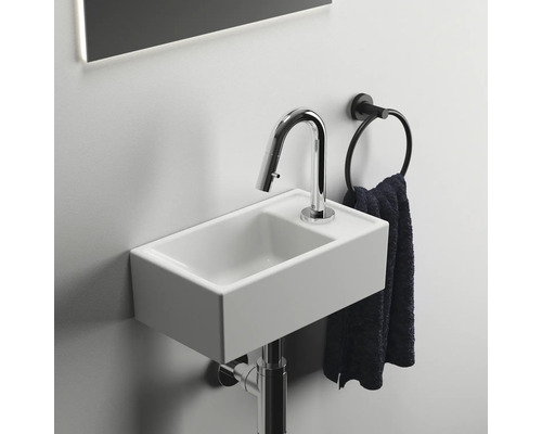 Kleines Waschbecken mit Armatur und Handtuchring im Badezimmer