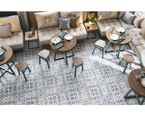 Intérieur avec coin salon, tables et carrelage à motifs