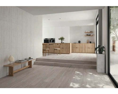 Espace de vie lumineux avec parquet, banc et cuisine ouverte.