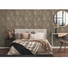 Schlafzimmer mit Bett vor gemusterter Tapete mit Blättern