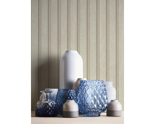 Vases décoratifs de différentes formes et matériaux devant un mur à aspect bois.