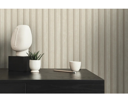 Gros plan d''un mur avec du papier peint à panneaux de bois, une sculpture, une plante et une tasse sur une table.