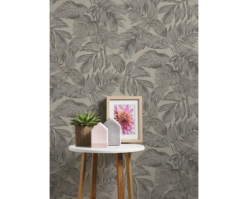 Gros plan d''un mur avec du papier peint à feuilles et une table avec des décorations