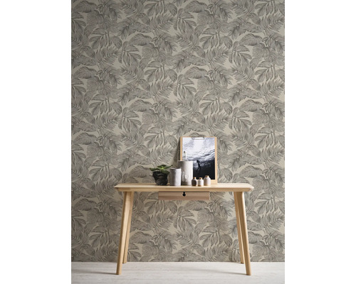 Vue d''une pièce avec papier peint à motif de feuilles, table en bois, plante, décoration et image encadrée