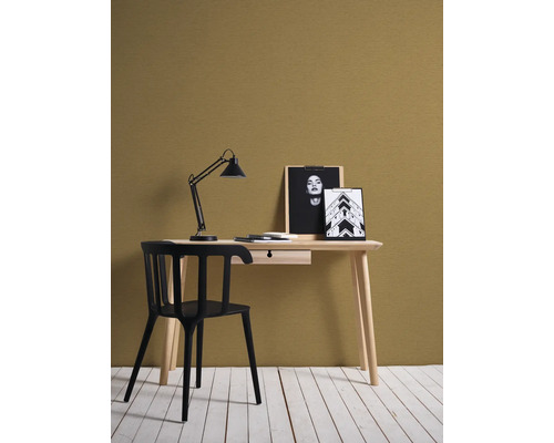 Bureau avec lampe de bureau, chaise et objets de décoration dans une pièce lumineuse.