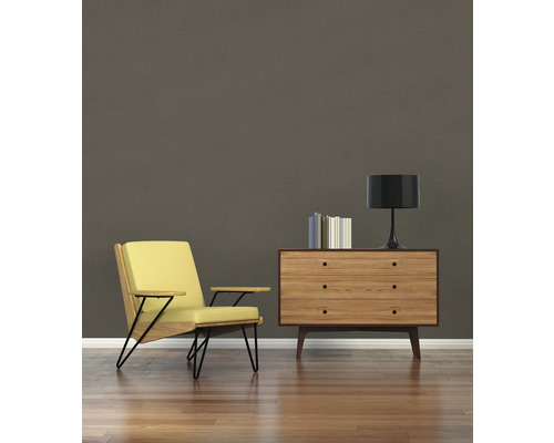 Salon avec fauteuil, commode, lampe et livres