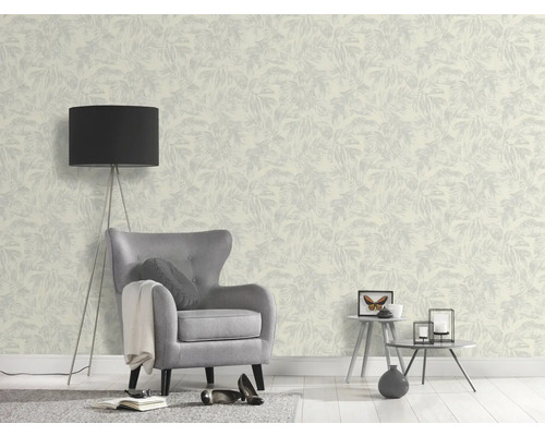 Une pièce avec un papier peint à motifs, un fauteuil et un lampadaire.