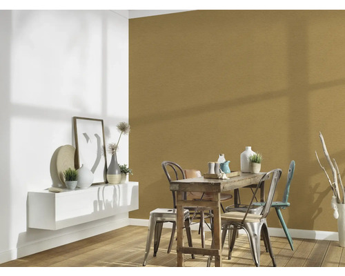 Salle à manger avec table en bois, chaises et décoration murale dorée