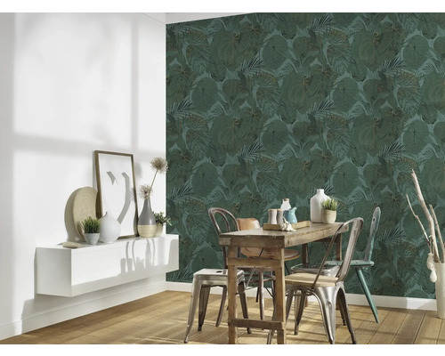 Salle à manger avec table en bois, chaises et mur avec papier peint à feuilles