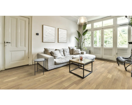 Séjour lumineux avec parquet, canapé et fenêtres