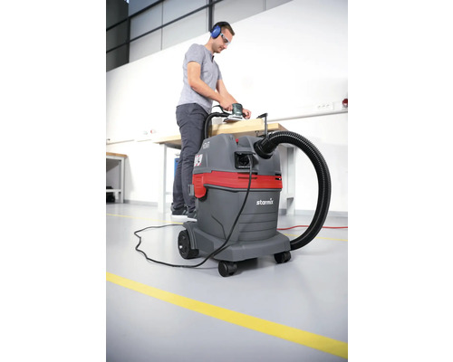 Homme ponçant du bois avec un aspirateur pour l''extraction de la poussière