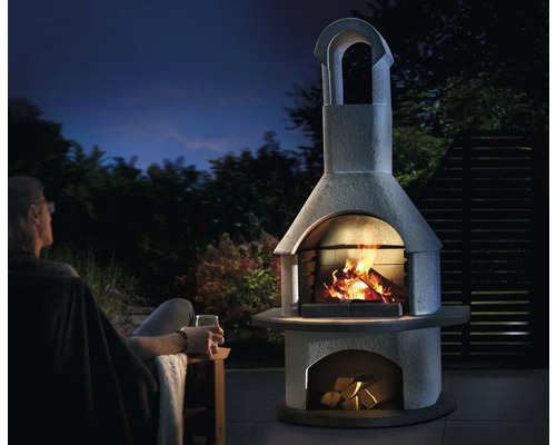 Cheminée d''extérieur en pierre avec feu et bois en plein air