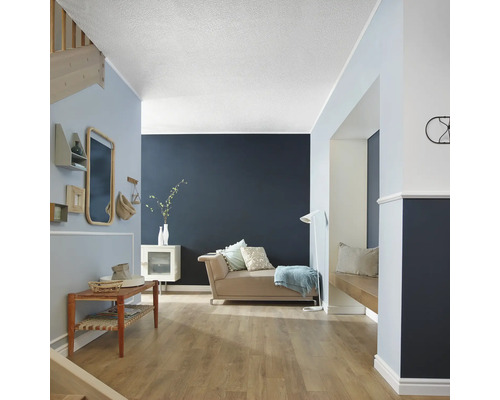 Wohnzimmer mit Laminatboden, Couch und Wanddekoration