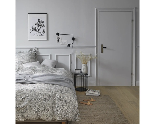 Chambre avec lit, table de chevet, lampe et décoration