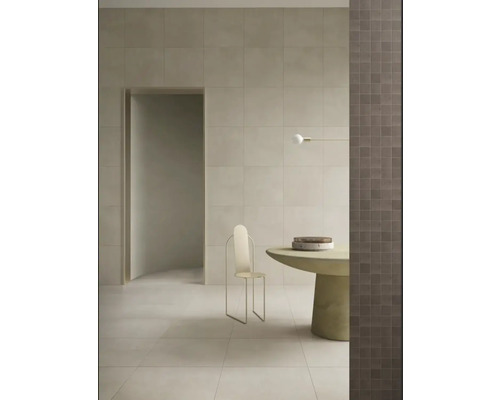 Heller Raum mit Fliesenboden, Fliesenwand, Tisch und Stuhl