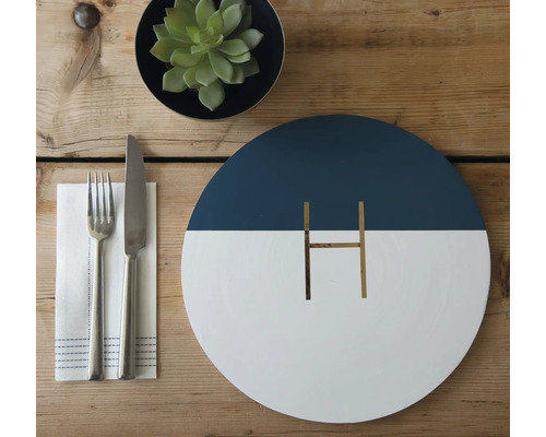 Dekorativer Tisch mit Besteck, Serviette und Pflanze als Tischdekoration