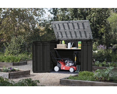 Geöffneter Gartenschrank mit Gartengeräten im Garten