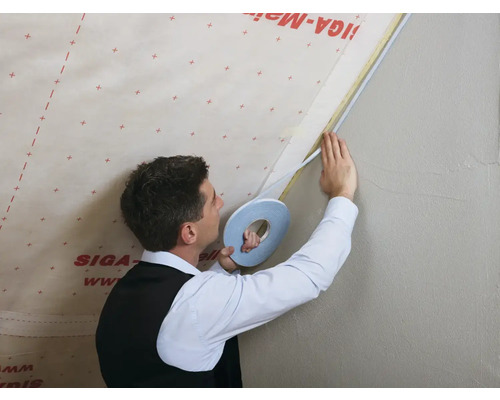 Artisan fixant du ruban d''étanchéité sur un mur