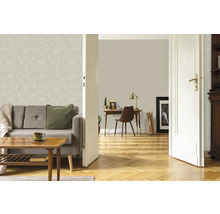 Salon lumineux avec papier peint à motifs floraux, canapé et parquet