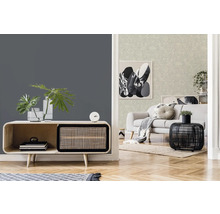 Salon avec mur gris, commode, objets de décoration et canapé en arrière-plan