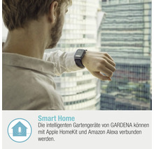 Ein Mann mit einer Smartwatch vor einem Fenster mit Blick auf ein Gebäude.