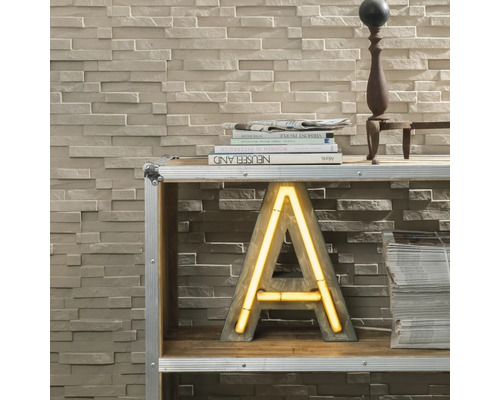 Mur décoratif avec panneaux de pierre et étagère avec lettres décoratives