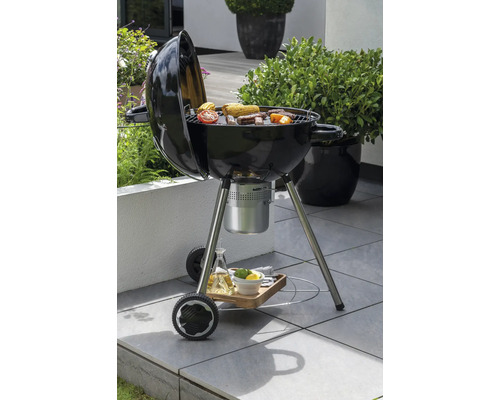 Kugelgrill mit Grillgut im Garten