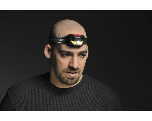 Homme portant une lampe frontale Ansmann