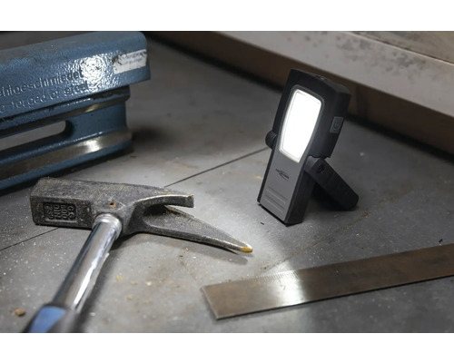 L''image montre un marteau, une équerre et une lampe de travail.