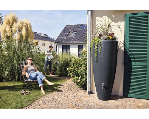 Szene im Garten mit Regentonne, Mann beim Giessen und Frau im Liegestuhl