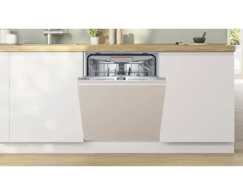 Lave-vaisselle encastrable dans une cuisine équipée avec porte ouverte.