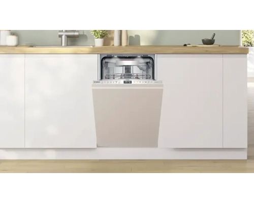 Lave-vaisselle intégré dans une cuisine moderne avec des armoires blanches et du bois clair