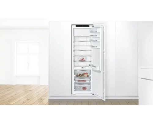 Geöffneter Einbaukühlschrank mit Lebensmitteln in einer hellen Küche.