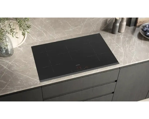 Table de cuisson à induction noire sur un comptoir de cuisine.