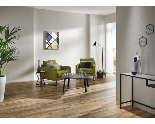 Heller Wohnraum mit Holzboden, zwei grünen Sesseln, Couchtisch und moderner Dekoration