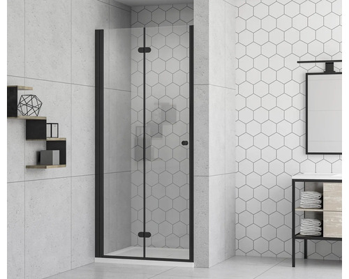 Salle de bain avec cabine de douche avec porte pliante et cadre noir devant des carreaux hexagonaux.