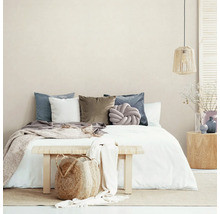 Schlafzimmer mit Bett, Kissen, Tagesdecke, Bank und Dekoration für eine gemütliche Atmosphäre