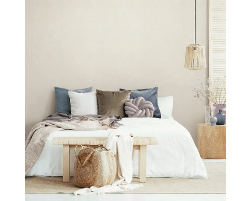 Schlafzimmer mit Bett, Kissen, Tagesdecke, Bank und Dekoration für eine gemütliche Atmosphäre