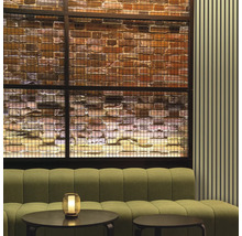 Innenraum mit Sofa, Tischen und dekorativer Ziegelwand hinter einem Metallgitter