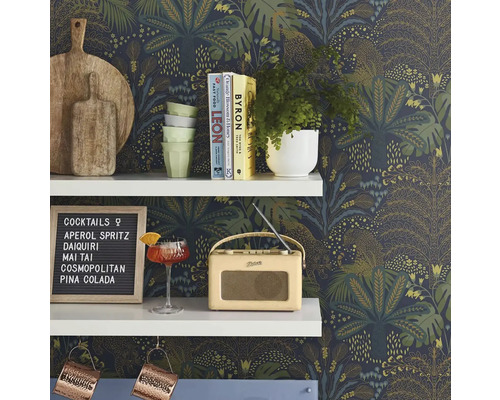 Dekoratives Regal mit Schneidebrettern, Geschirr, Pflanzen, Cocktail, Radio und Cocktailkarte vor einer bedruckten Tapete