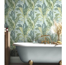 Salle de bains avec baignoire et papier peint jungle à motifs végétaux.